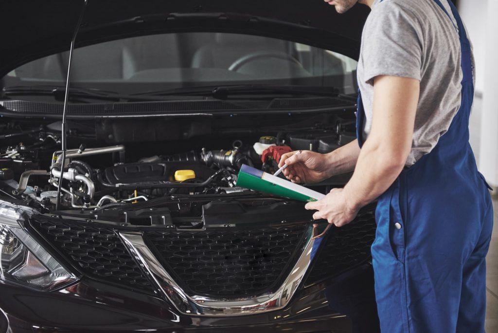 Mechanic with MOT checklist. We look at how long an MOT takes