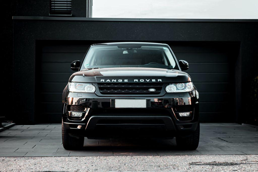 Black Range Rover outside of a charcoal coloured garage.